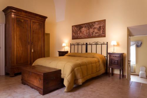 a bedroom with a large bed and a wooden cabinet at La Casa di Ele in Matera