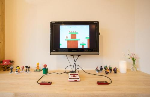a television sitting on top of a table with toy figurines at Mulan Hostel in Kyoto
