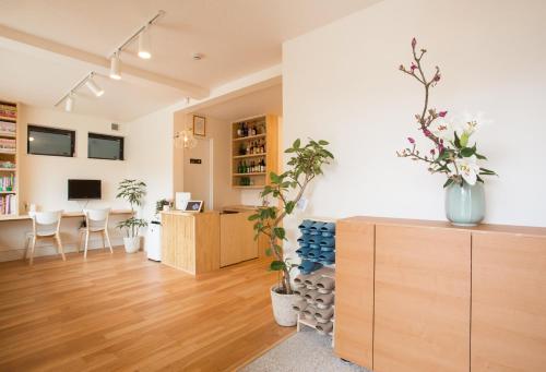 a living room with a desk and a table with plants at Mulan Hostel in Kyoto