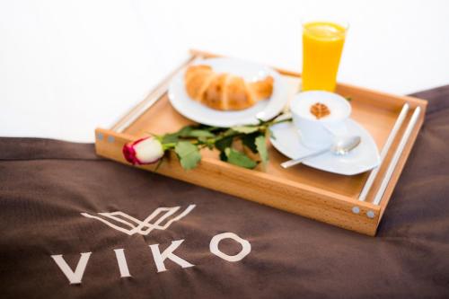 a tray with a plate of food and a cup of orange juice at VIKO Boutique Apart Hotel in Sofia
