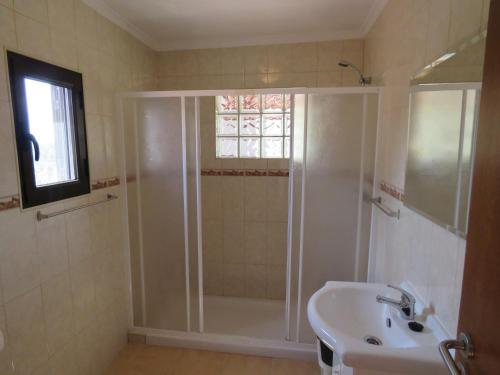 un baño con ducha y lavabo en Harmonia, en Ouzenda