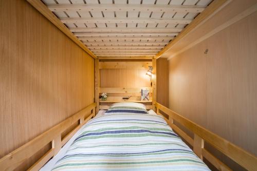 two beds in a room with wooden walls at Mulan Hostel in Kyoto