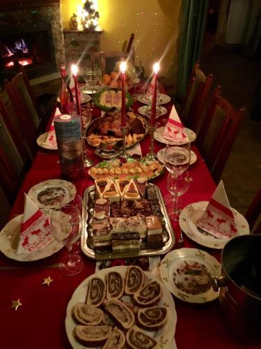a long table with a red table cloth with food on it at Aranypatkó Vendégház Lovasudvar in Berzence