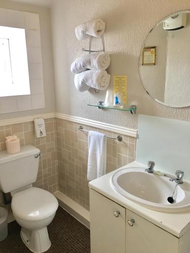 a bathroom with a toilet and a sink and a mirror at Corona Blackpool in Blackpool