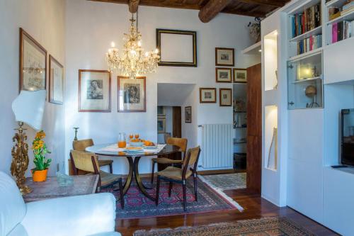 uma sala de jantar com uma mesa e cadeiras e um lustre em Antica Dimora San Pellegrino em Viterbo