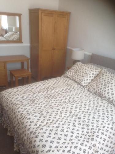 a bedroom with a bed and a dresser and a mirror at Knights Rest in Shanklin