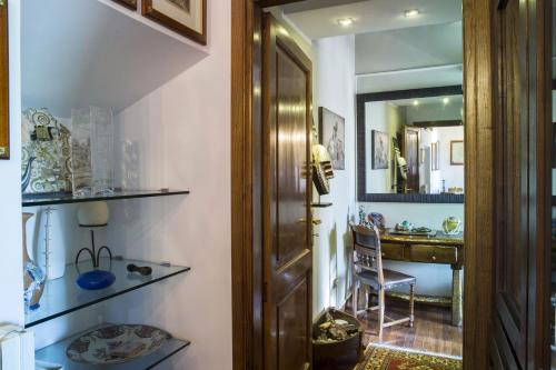 pasillo con puerta, silla y espejo en Antica Dimora San Pellegrino, en Viterbo