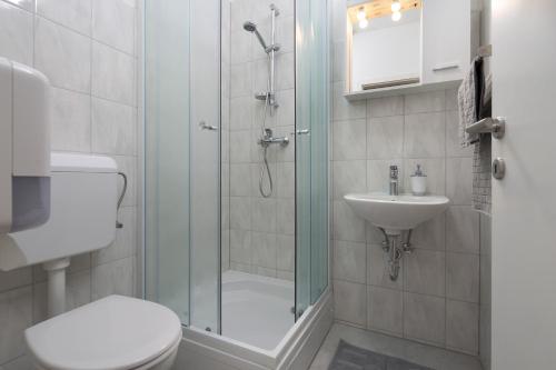 a bathroom with a shower and a toilet and a sink at Hostel Bureau in Zagreb
