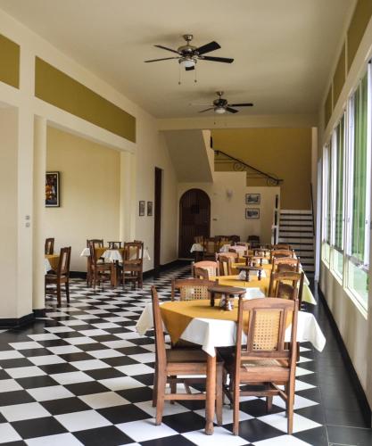 a restaurant with tables and chairs on a checkered floor at Pizzeria Colisseo B & B in Jinotepe