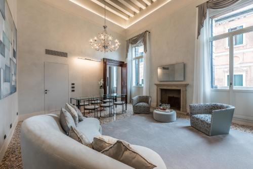 Palazzo Morosini Degli Spezieri - Apartments في البندقية: غرفة معيشة مع أريكة ومدفأة