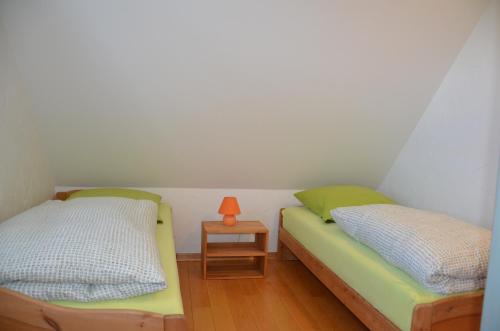 two beds in a room with a side table at Hofgut Wollin GmbH in Putgarten