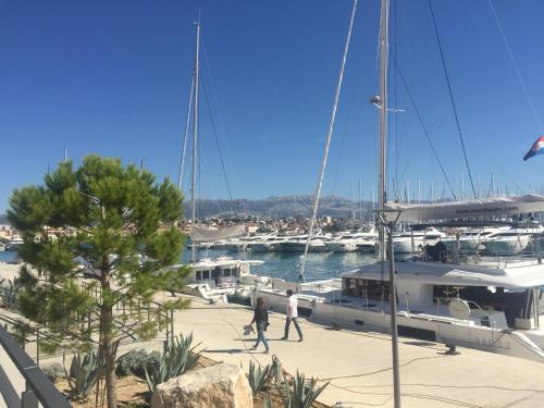 dos personas caminando por delante de un barco en un puerto deportivo en Iva Apartment Split, en Split