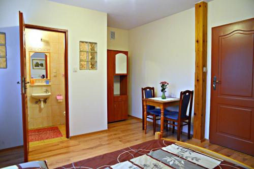 a living room with a table and a bathroom at Willa Kamieniec in Polańczyk
