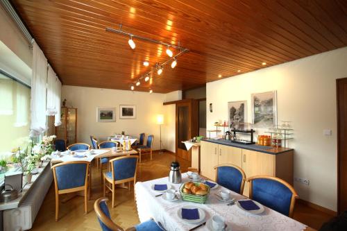 Hotel garni Zum Drosten في Balve: غرفة طعام مع طاولات وكراسي ومطبخ