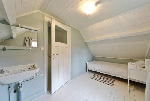 オーストダインケルケにあるVakantiehuis Strandpieperのバスルーム(シンク付)、ベッド1台が備わります。