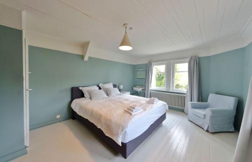 オーストダインケルケにあるVakantiehuis Strandpieperの青いベッドルーム(ベッド1台、椅子付)