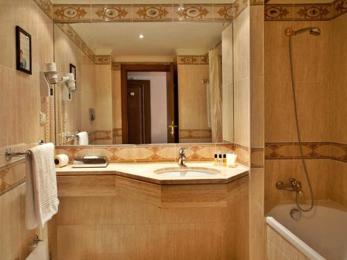 łazienka z umywalką i dużym lustrem w obiekcie TURIM Lisboa Hotel w Lizbonie