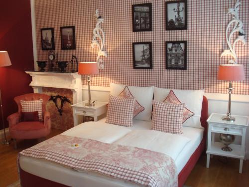 a bedroom with a bed with pillows and a fireplace at Hotel Sir & Lady Astor in Düsseldorf