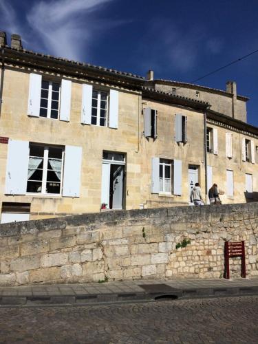 duas pessoas de pé numa parede em frente a um edifício em La Maison Colline em Saint-Émilion