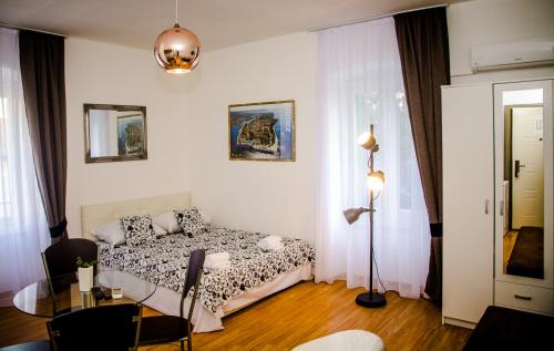 een slaapkamer met een bed en een tafel. bij Apartments Branimir in Zadar