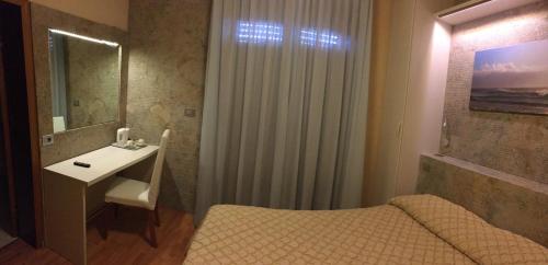 a bathroom with a bed and a sink and a mirror at Hotel da Filie' in Querceta