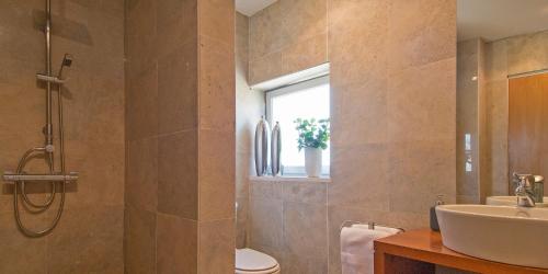 een badkamer met een wastafel, een toilet en een raam bij Quinta Luz do Sol in Moncarapacho