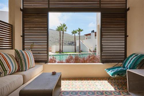 a living room with a couch and a large window at Hotel San Cristobal Adults 15+ in Todos Santos