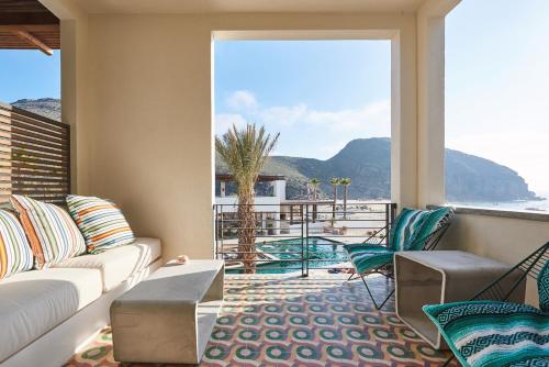a living room with a couch and a view of the ocean at Hotel San Cristobal Adults 15+ in Todos Santos