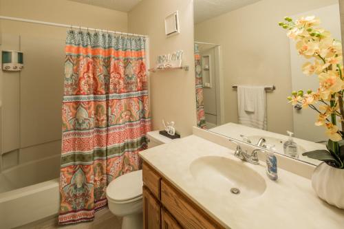 a bathroom with a sink and a toilet and a shower curtain at Sea Vista in South Padre Island