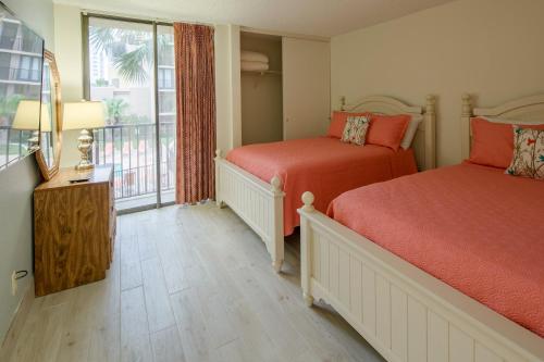 a bedroom with two beds and a window with a view at Sea Vista in South Padre Island