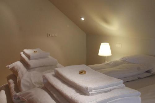 a room with white towels stacked on a bed at Askja Apartment in Húsavík