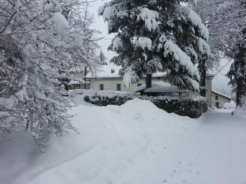 a yard covered in snow in front of a house at Il Casolare Bioenergetico in Albareto