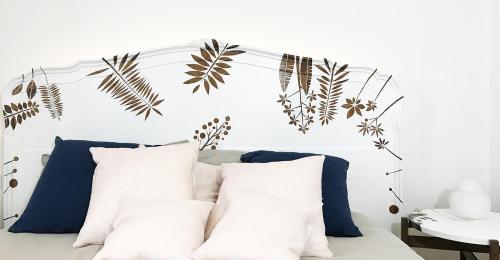 a bed with white pillows and plants on it at Castagna Amara in Montevecchia