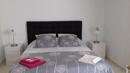 a bedroom with a bed with a red bag on it at Chambres d'Hôtes Le Mas du Bijou Bleu in Puget-sur Argens