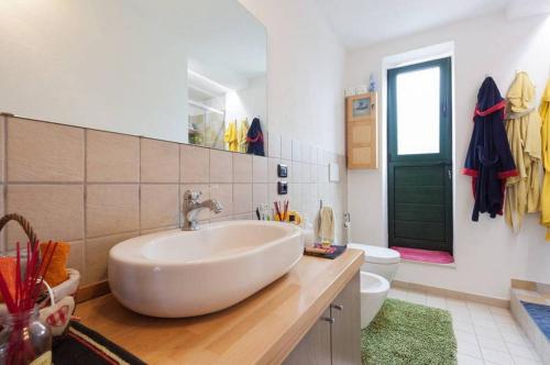 a white bathroom with a sink and a toilet at Relais des Roches in Sona