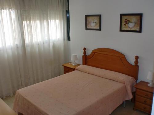una camera da letto con un letto e una finestra con tende di Kennedy 2 - Fincas Arena a Benidorm