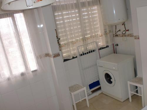 un bagno con lavatrice e WC di Kennedy 2 - Fincas Arena a Benidorm