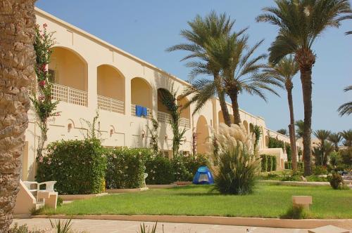 a building with palm trees in front of it at Zephir Hôtel & Spa in Zarzis