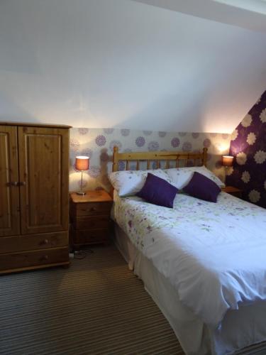 a bedroom with a white bed and a wooden cabinet at Victoria Lodge in Sandown