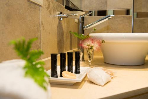 a bathroom counter with a sink and a toothbrush holder at Falls Iguazú Hotel & Spa in Puerto Iguazú