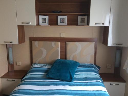 a bed with a blue pillow on top of it at Warren Retreat in Dawlish