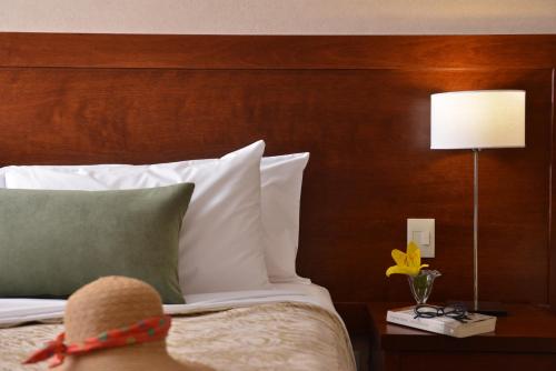 a person sitting on a bed with a hat on it at Falls Iguazú Hotel & Spa in Puerto Iguazú