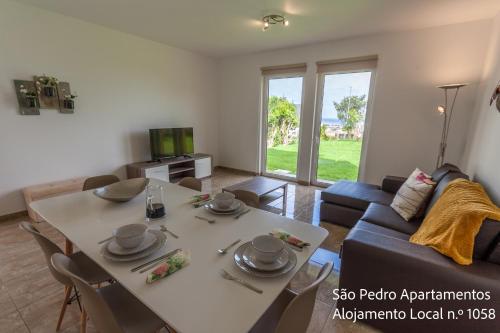 a living room with a table and a couch at São Pedro Apartamentos in Horta