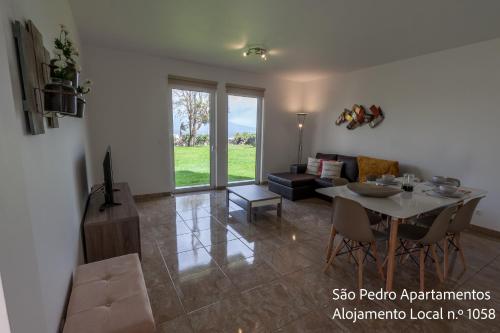a living room with a table and a couch at São Pedro Apartamentos in Horta