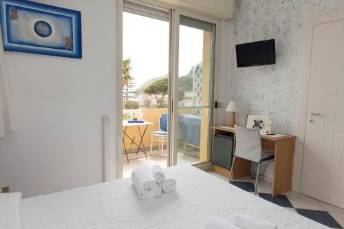 Pokój hotelowy z łóżkiem, biurkiem i oknem w obiekcie Lewis Rooms Poetto Beach w Cagliari