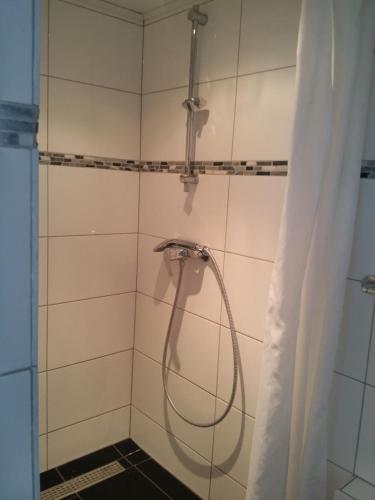 y baño con ducha y manguera. en Vakantiewoning Kleijnen en Noorbeek