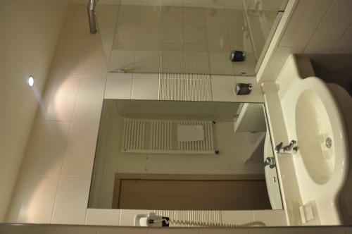 a bathroom with a mirror and a sink at Grand Hotel Olimpo in Alberobello
