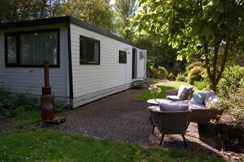 a cabin with a couch and a chair in a yard at Vakantieverblijf op een uniek landgoed bij zee in Kamperland