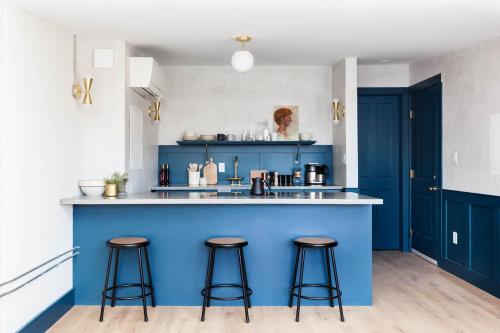 a blue kitchen with stools at a blue island at Lokal Hotel Old City in Philadelphia