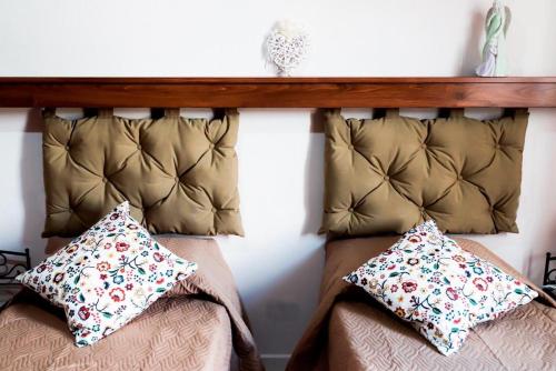 a bed with two pillows and a wooden headboard at INFORMIS B&B in Capua
